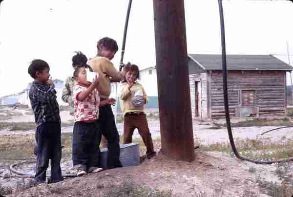 5 youngsters obtaining water from hose. 7/71